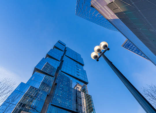 a street light in front of tall glass skyscrapers