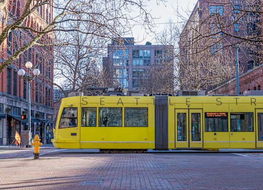 a yellow streetcar on the street in the city