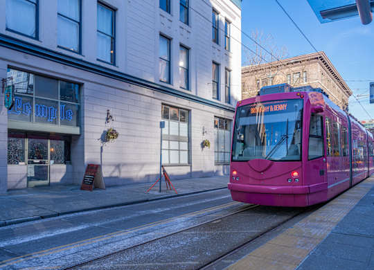 a pink streetcar on a city street