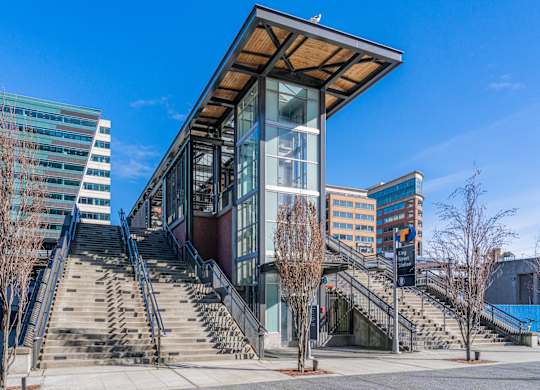 a modern building with stairs and a large glass elevator