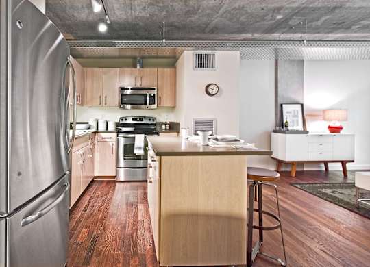 a kitchen with a island and a stainless steel refrigerator