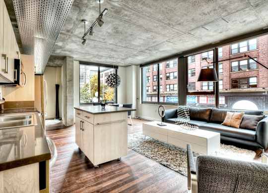 a living room with a kitchen and a large window