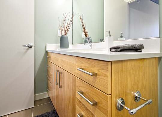 a bathroom with wooden cabinets and a sink and a mirror