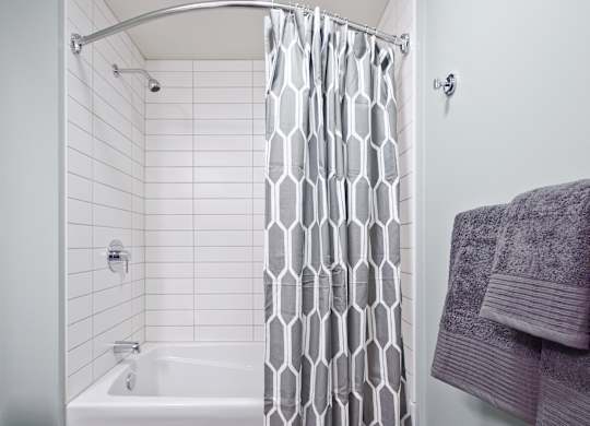 a white bathroom with a shower curtain and a sink