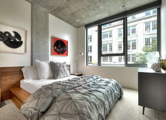 a bedroom with a bed and a large window
