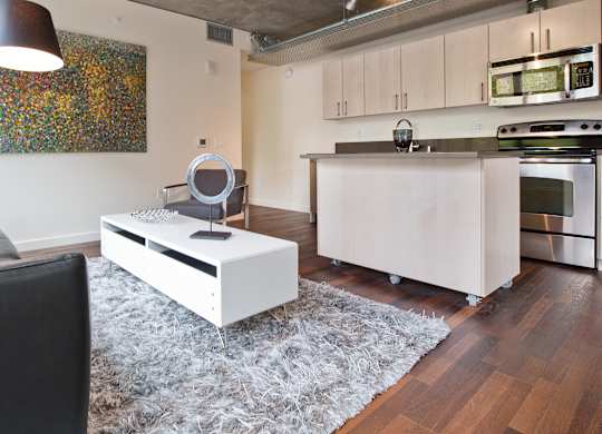 a living room with a couch and a coffee table in front of a kitchen