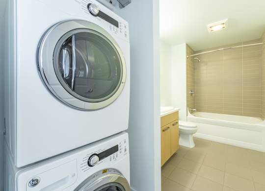 a washer and dryer in a laundry room next to a bathroom