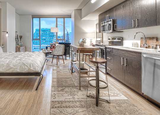 a bedroom with a bed and a kitchen with a sink