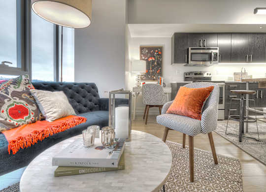 a living room and kitchen with a blue couch and a table