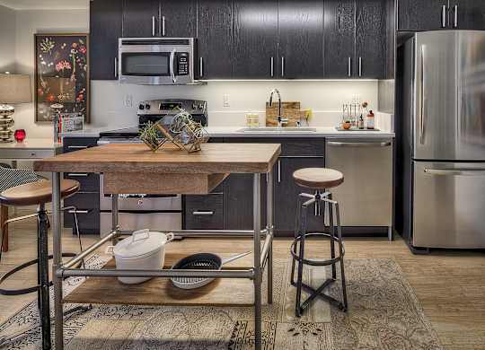 a kitchen with stainless steel appliances and a wooden table