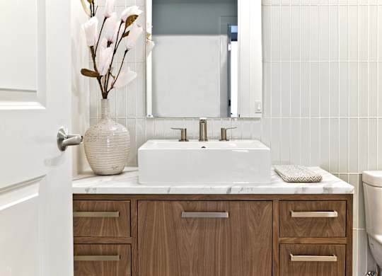 a bathroom with a white sink and a vase with flowers