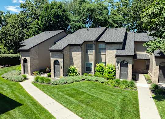 A house with a grey roof and a green lawn in front.