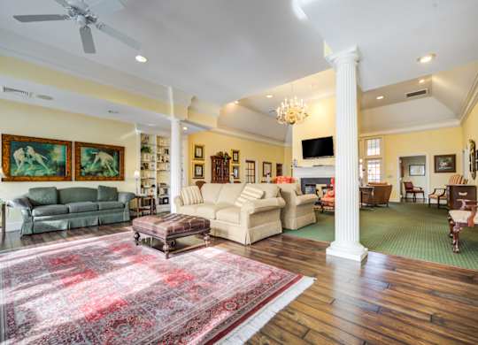 A living room with a rug on the floor and a white column in the middle at Highlands at Warwick Apartments, Lilitz, PA