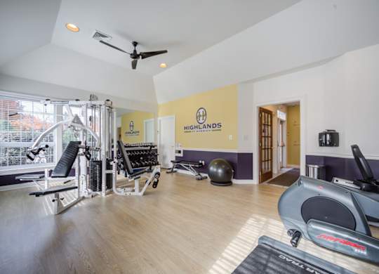 A gym with a variety of equipment including a treadmill, rowing machine, and weights at Highlands at Warwick Apartments, Lilitz, PA