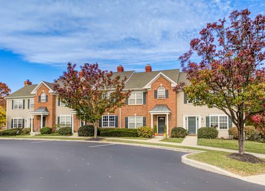 A large brick house with a green lawn in front at Highlands at Warwick Apartments, Lilitz, PA