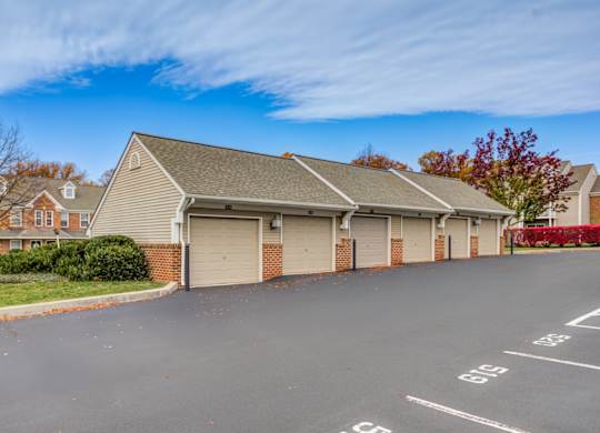 A two-car garage is located in front of a brick house at Highlands at Warwick Apartments, Pennsylvania