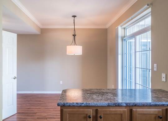 A kitchen with a granite countertop and wooden cabinets at Highlands at Warwick Apartments, Pennsylvania 17543