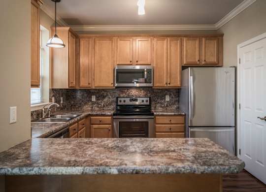 A kitchen with granite countertops and wooden cabinets at Highlands at Warwick Apartments, Pennsylvania