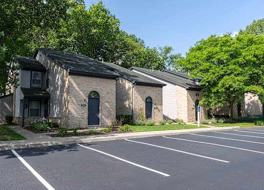 A parking lot in front of a building with a black roof.