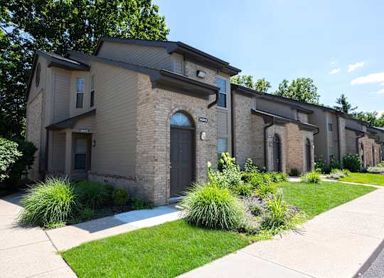 A row of houses with a sidewalk in front.