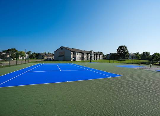 A tennis court with a blue surface and white lines.