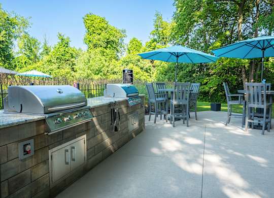 A sunny day at the outdoor grill area with blue umbrellas providing shade.