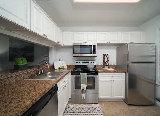 A kitchen with a stove top oven and a refrigerator.