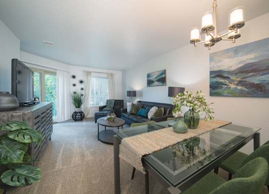 A living room with a glass table and green chairs.