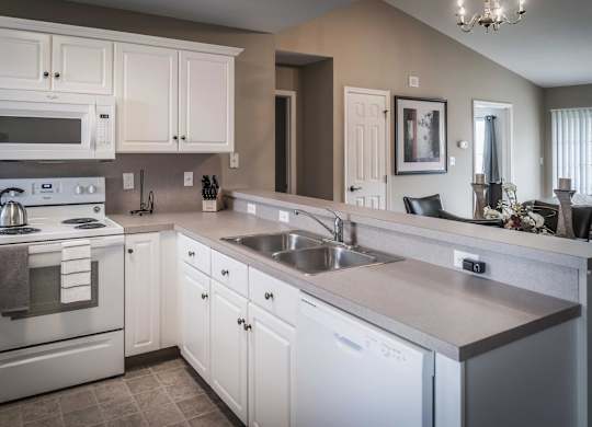 A kitchen with white cabinets and stainless steel appliances at Highlands at Warwick Apartments, Lilitz