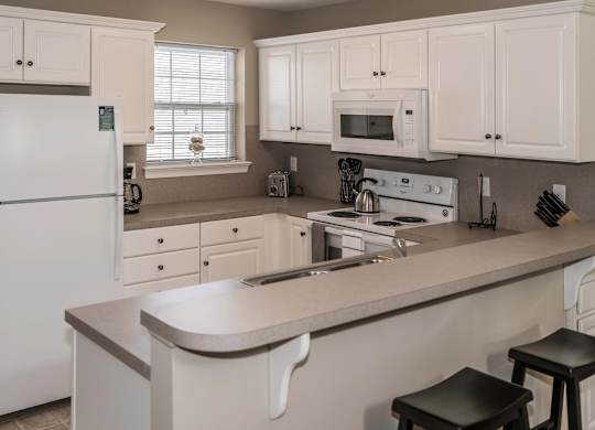 A white kitchen with a refrigerator, microwave, oven, and sink at Highlands at Warwick Apartments, Lilitz, PA 17543