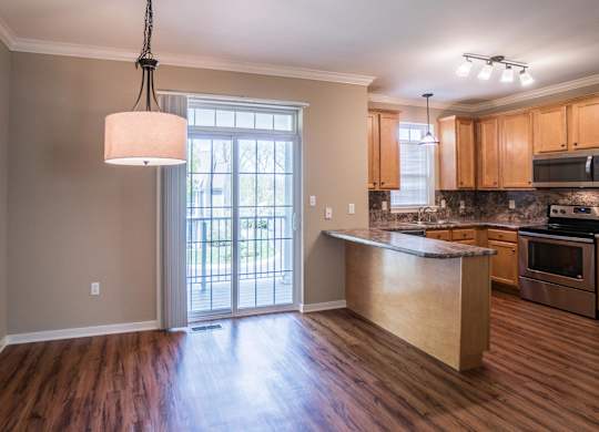 A kitchen with wooden floors and a large island at Highlands at Warwick Apartments, Lilitz, PA