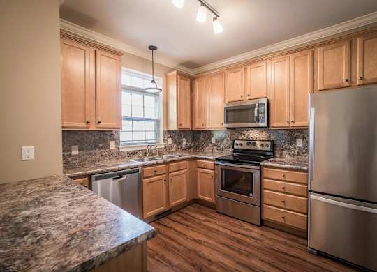 A kitchen with wooden cabinets and stainless steel appliances at Highlands at Warwick Apartments, Lilitz, 17543