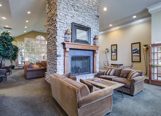 A living room with a stone fireplace and a couch at The Crest at Elm Tree, Mount Joy, PA 17552