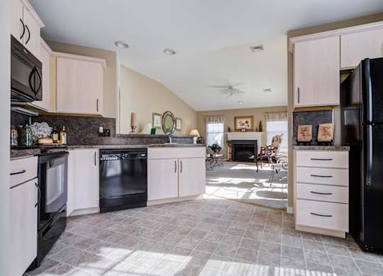 A kitchen with black appliances and white cabinets at The Crest at Elm Tree, Mount Joy, PA 17552