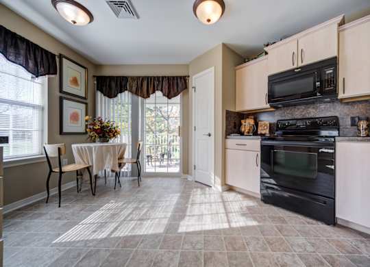 A kitchen with a table and chairs in front of a window at The Crest at Elm Tree, Mount Joy Pennsylvania