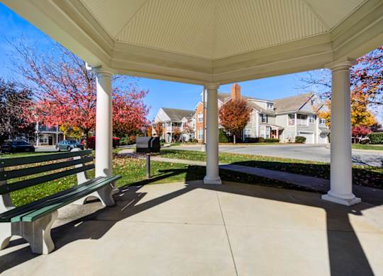 A covered bench area with a white roof and a green bench at The Crest at Elm Tree, Pennsylvania 17552
