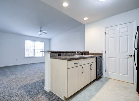 A kitchen with a countertop and cabinets is shown at The Crest at Elm Tree, Mount Joy