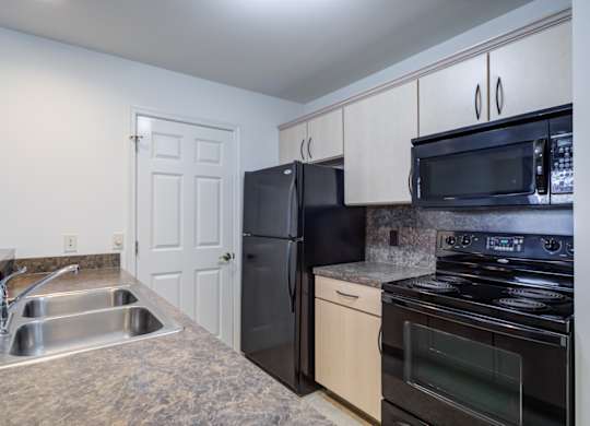 A kitchen with black appliances and a sink at The Crest at Elm Tree, Mount Joy Pennsylvania