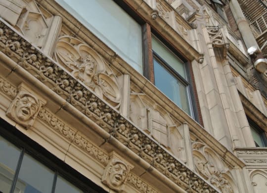 the facade of a building with columns and gargoyles at Garment Lofts, Los Angeles, CA 