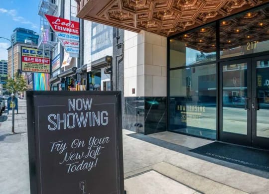 a now showing sign in front of a building at Garment Lofts, Los Angeles, CA
