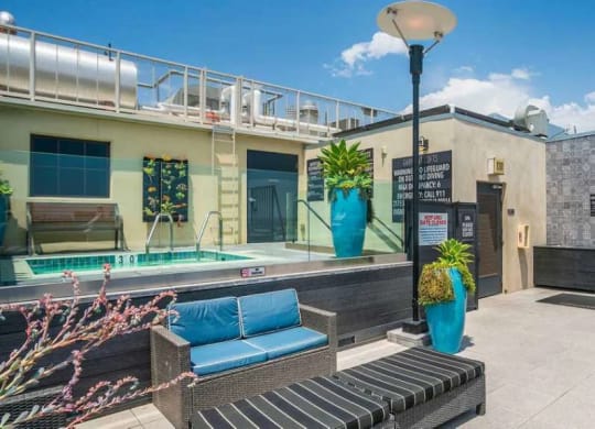 the pool area of a building with a pool and lounge chairs at Garment Lofts, Los Angeles, 90014