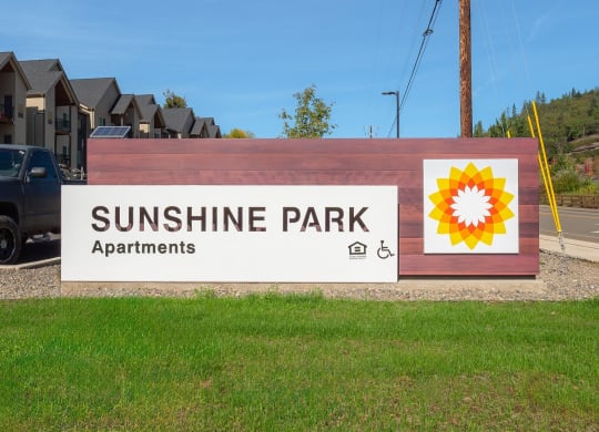 a sign for sunshine park apartments with a sunflower on it
