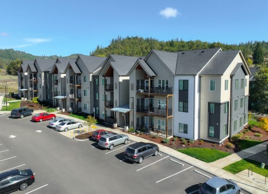 an aerial view of an apartment complex with cars parked in a parking lot