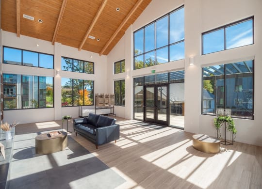 a living room with large windows and a black couch