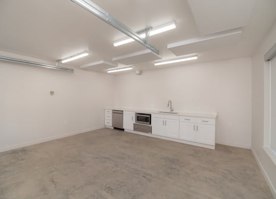 the interior of an empty room with white cabinets and a counter top and a sink