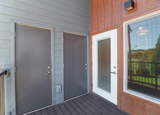 a porch with two doors and a glass window