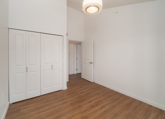 an empty living room with white walls and wood flooring