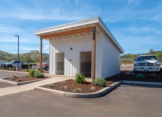 a parking lot with a white building with a car parked in it