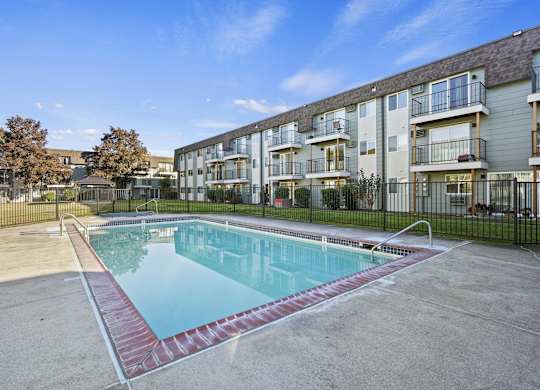 a swimming pool in front of an apartment building