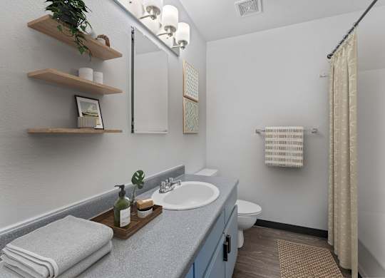 A bathroom with a white sink and a toilet.